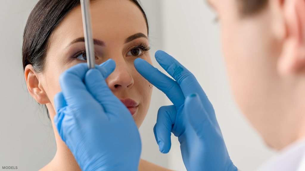 Doctor analyzing woman's nose (models)