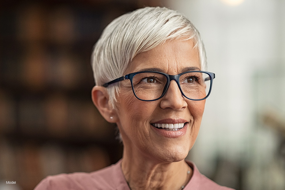 Mature woman with white hair and glasses